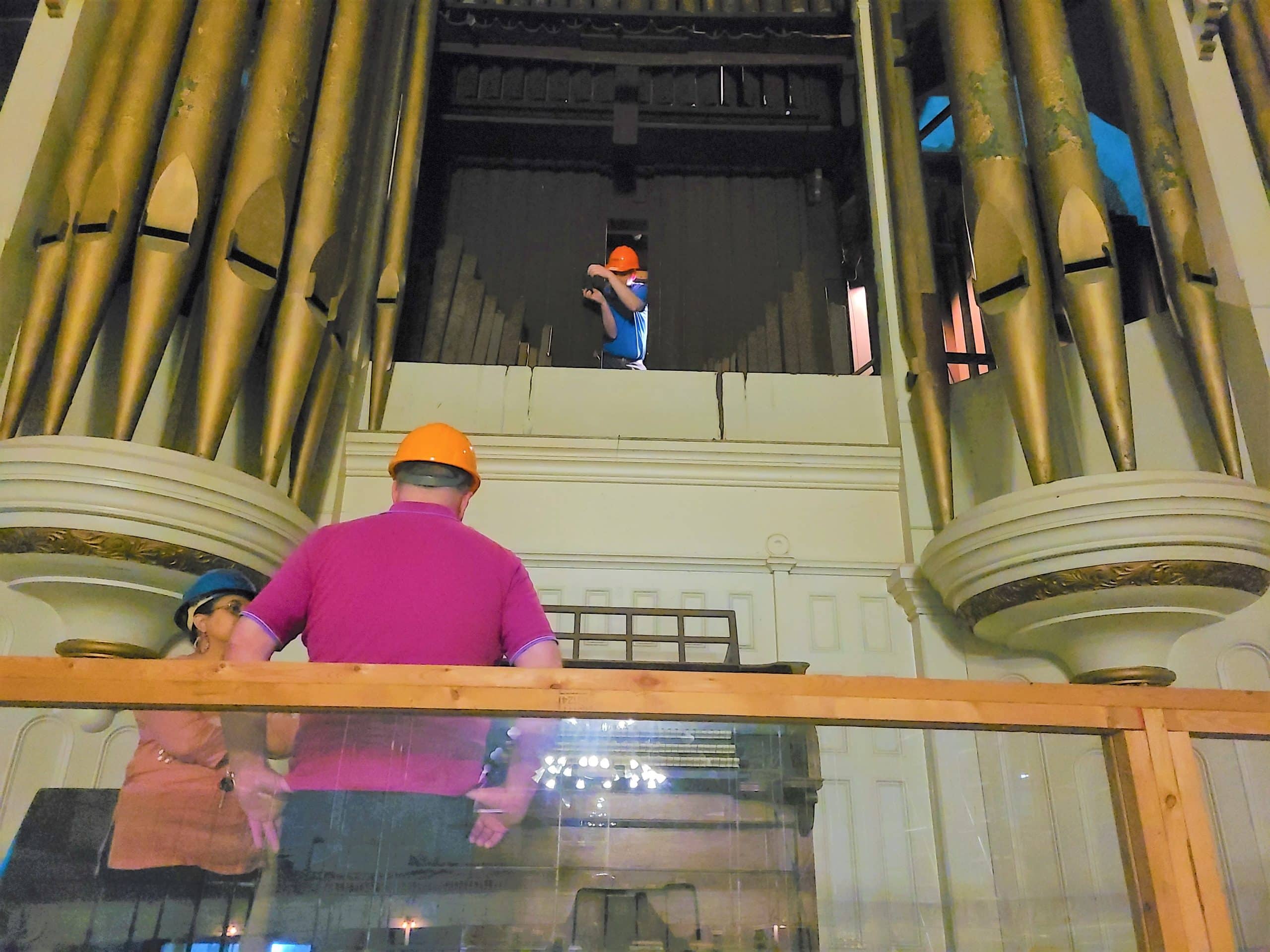 Organ restoration workers examine the historic organ